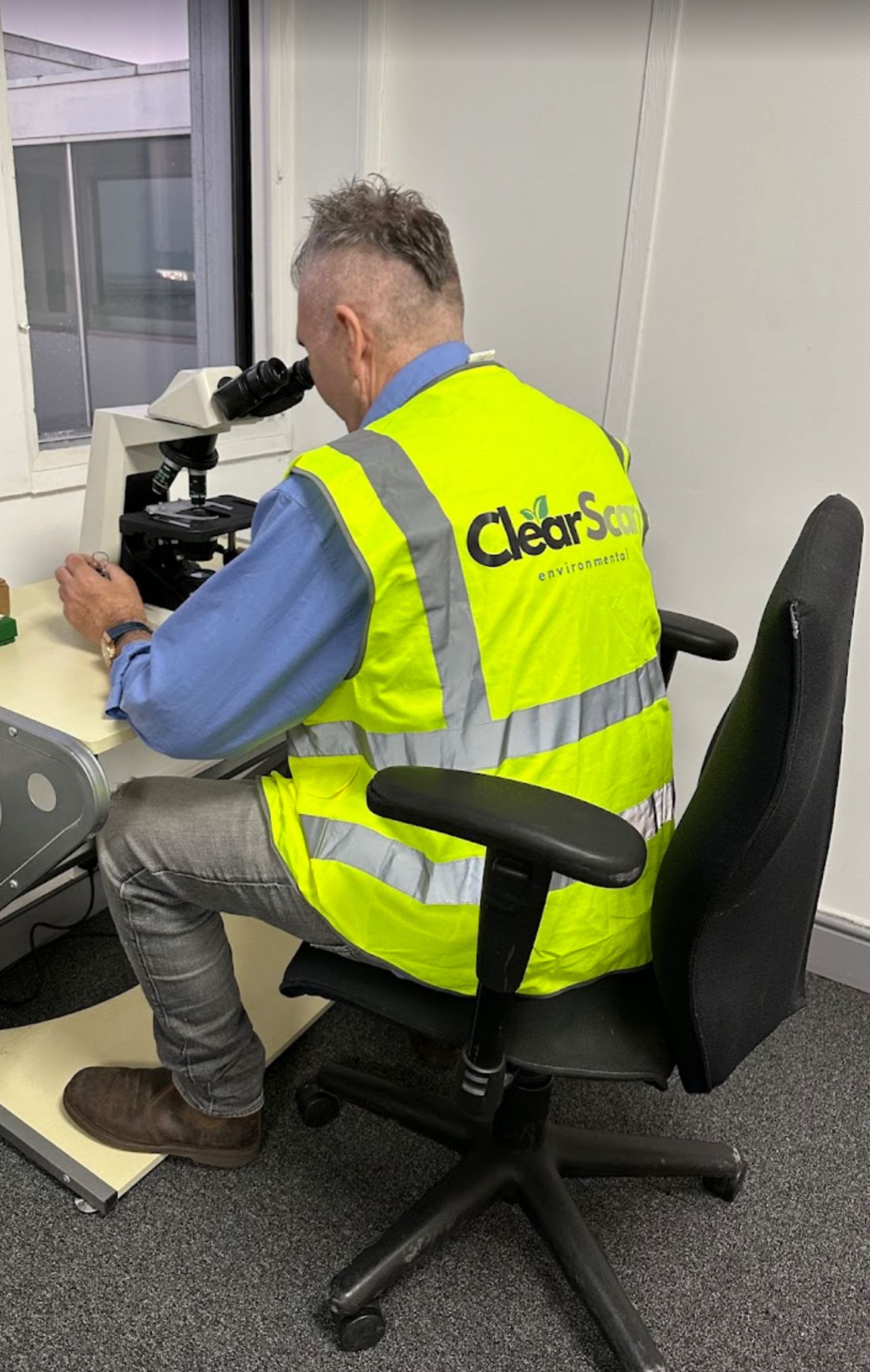 Professional air monitoring equipment and operative conducting asbestos clearance testing at utilities facility